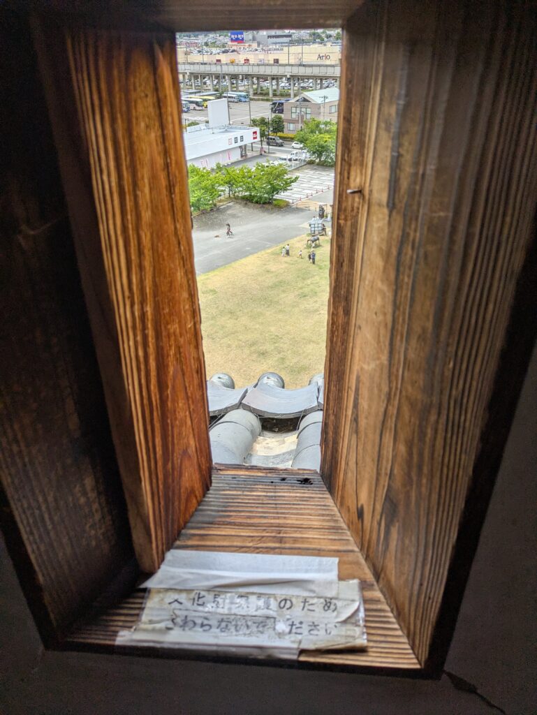 从上田城橹窗口远眺城下町街景与瓦片屋顶的视角