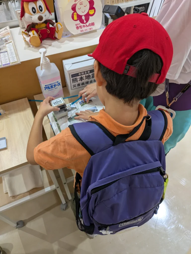 在福冈城三之丸广场盖日本100名城印章的孩子(背影)